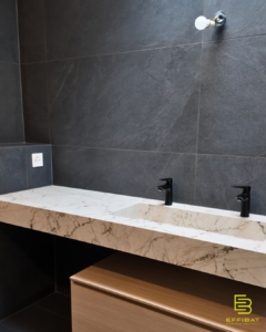 the master bathroom in gray tile and marble counter