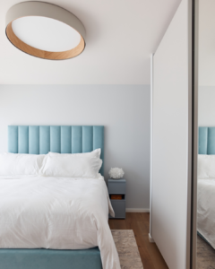 More pastel blues in another bedroom of the home with wooden light on the ceiling