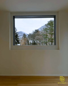 The view of a forest and mountains from a west-facing window
